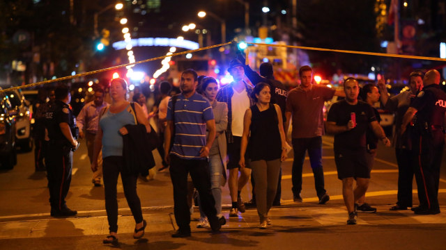 Polisi mensterilkan di lokasi penembakan di Toronto, Kanada, Minggu (22/7). (Foto: Reuters/Chris Helgren)