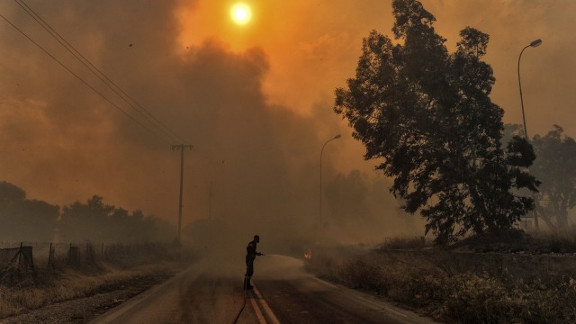 Saat petugas mencoba untuk memadamkan area kebakaran hutan di Kineta, Athena, Yunani. (Foto: AFP/Valerie Gache)