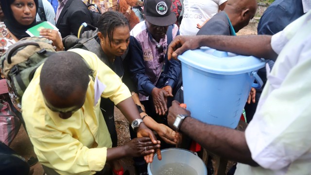 Seorang pekerja kesehatan Kongo mensosialisasikan penduduk tentang mencuci tangan mereka sebagai tindakan pencegahan terhadap Ebola di Mbandaka, Republik Demokratik Kongo 19 Mei 2018.  Foto: Reuters/Kenny Katombe