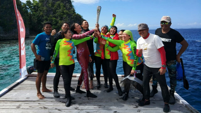 Replika obor Asian Games 2018  dibawa menyelam oleh Ny Tri Tito Karnavian didampingi Nadine Chandrawinata, bersama penyelam lainnya di Hidden Bay. Piaynemo, Raja Ampat,  (Foto: Dok. Humas Polri)