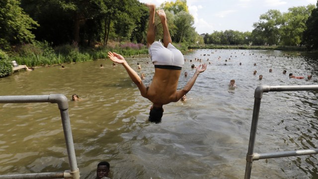 Akibat gelombang panas masyarakat berenang di kolam campuran di Hampstead Heath di London (26/7). (Foto: AFP/Akmen)