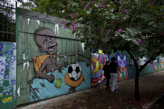 Mural  Paulo Ito di Piala Dunia 2014. (Foto: NELSON ALMEIDA / AFP)
