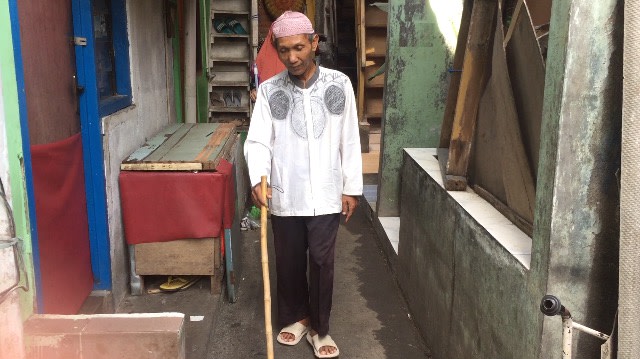 Sarono, tukang pemecah batu, berjalan dengan tongkat. (Foto: Fachrizal H./kumparan)