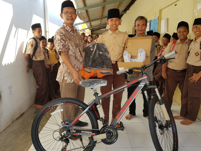 Atlet lari asal Pekalongan, A Rizal Akbar menerima kado berupa sepeda, sepatu lari, serta tas sekolah dari Gubernur Provinsi Jawa Tengah, Ganjar Pranowo. (Foto: Dok. Humas Ganjar Pranowo)