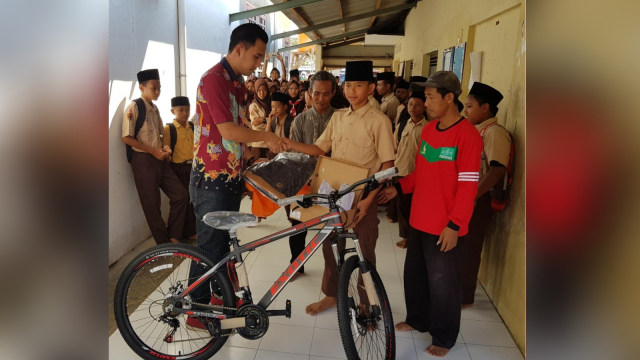 Atlet lari asal Pekalongan, A Rizal Akbar menerima kado berupa sepeda, sepatu lari, serta tas sekolah dari Gubernur Provinsi Jawa Tengah, Ganjar Pranowo. (Foto: Dok. Humas Ganjar Pranowo)