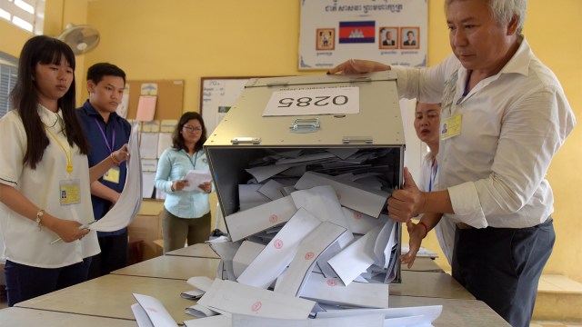 Panitia Pemilihan Umum Nasional Kamboja (NEC) mengosongkan kotak suara untuk menghitung selama pemilihan umum di  di Phnom Penh, Sabtu (28/7). (Foto: AFP PHOTO / Tang Chhin Sothy)