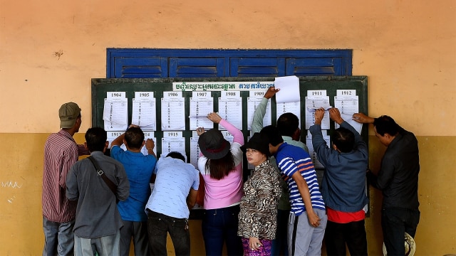 Warga Kamboja memeriksa nama mereka di daftar pemilih di sebuah TPS di Phnom Penh pada 29 Juli 2018. (Foto: AFP PHOTO / Manan Vatsyayana)