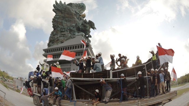 Sejumlah pekerja berada di atas kendaraan truk yang mengangkut modul terakhir dari Patung Garuda Wisnu Kencana (GWK) sebelum dipasang di Ungasan, Badung, Bali, Selasa (31/7). (Foto: Antara/Fikri Yusuf)