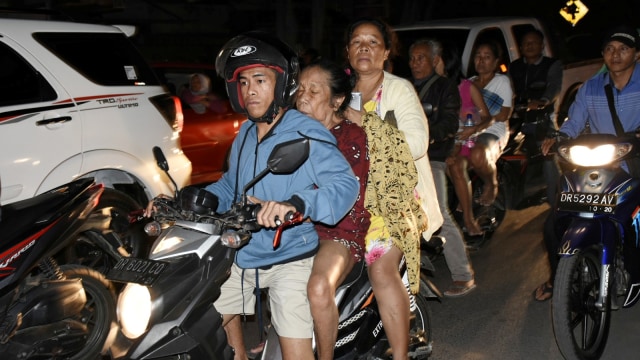 Warga yang panik menaiki sepeda motor ketika terjadi gempa berkekuatan 7 pada skala richter (SR) di Kecamatan Ampenan, Mataram, NTB, Minggu (5/8). (Foto: Antara/Ahmad Subaidi)