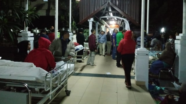 Situasi RSUP Sanglah, pasien dievakuasi sementara di selasar dan lobby pavilliun pasca gempa di Lombok, Minggu (5/8) malam. (Foto:  Cisilia Agustina Siahaan/kumparan)