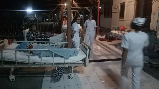 Situasi RSUP Sanglah, pasien dievakuasi sementara di selasar dan lobby pavilliun pasca gempa di Lombok, Minggu (5/8) malam.
 (Foto:  Cisilia Agustina Siahaan/kumparan)