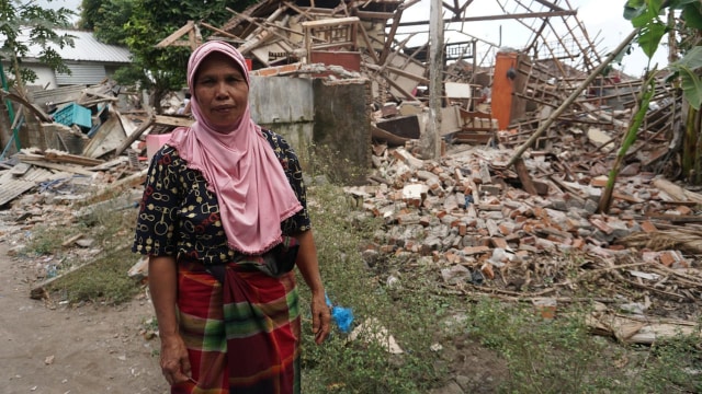 Warga berada di puing reruntuhan bangunan di Dusun Wadon, Desa Kekait, Kecamatan Gunung Sari, Kab. Lombok Utara, NTB, Senin (6/8). (Foto: Jamal Ramadhan/kumparan)