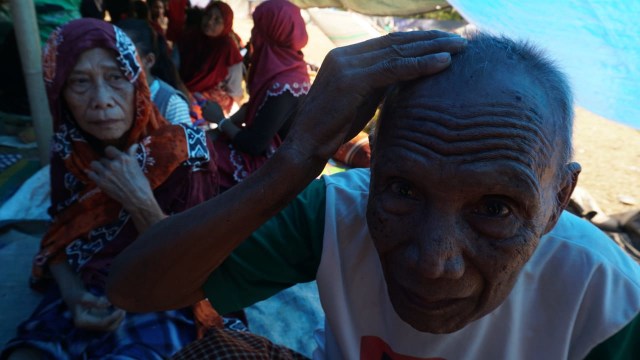 Kamaludin (83), menunjukan lukanya akibat tertimpa puing bangunan yang roboh di tempat pengungsian korban gempa Desa Menggala, Kec. Pemenang, Kab. Lombok Utara, NTB, Senin (6/8). (Foto: Jamal Ramadhan/kumparan)