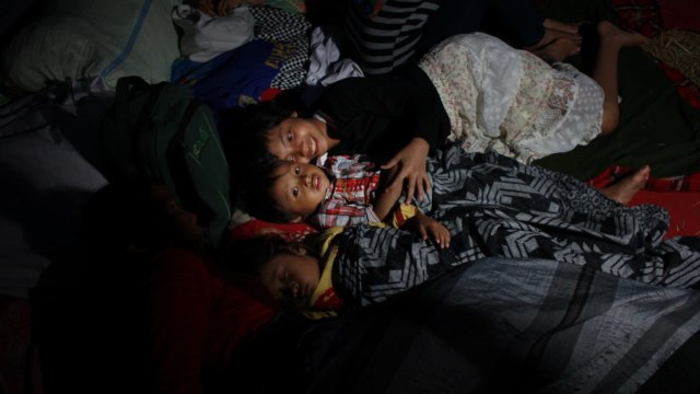 Aktivitas warga korban longsor saat malam hari di pengungsian yang berada di Kecamatan Tanjung, Lombok Utara, Selasa (7/8). (Foto: Jamal Ramadhan/kumparan)