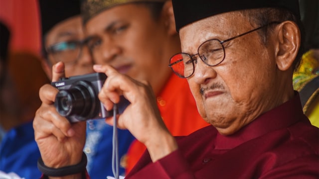 Presiden ke-3 Republik Indonesia B.J. Habibie memotret di kamera digitalnya saat menghadiri Peringatan HUT ke-61 Provinsi Riau di Kota Pekanbaru, Kamis (9/8). Foto: ANTARA FOTO/Retmon