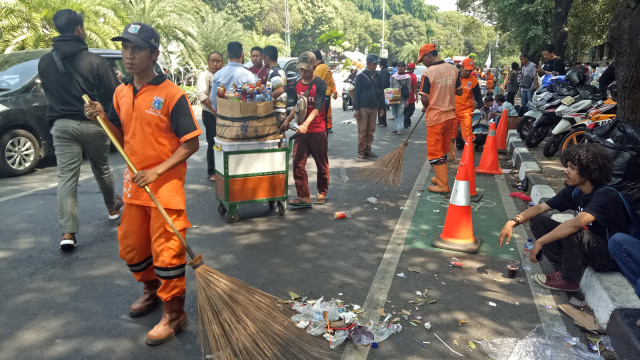 Pasukan oranye membersihkan jalanan depan Gedung KPU, Jalan Imam Bonjol, Jakarta Pusat, Jumat (10/8). (Foto:  Nabilla Fatiara/kumparan)