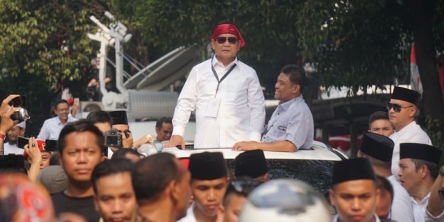 Prabowo Subianto memakai ikat kepala khas massa buruh Ditemani Presiden KSPI, Said Iqbal di sekitar Gedung KPU, Jumat (10/8/2018). Foto: Nugroho Sejati/kumparan