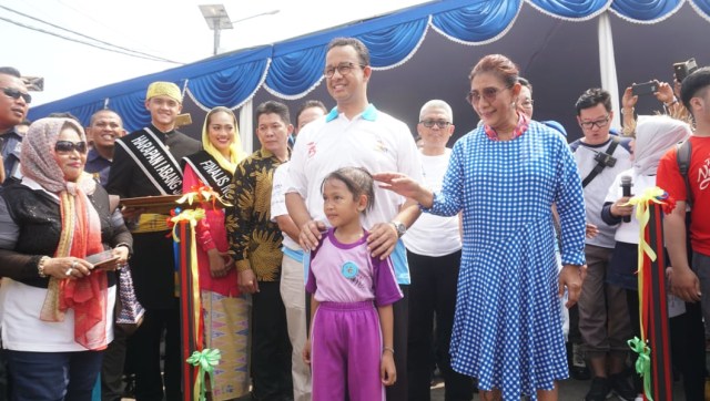 Menteri Kelautan Dan Perikanan Susi Pujiastuti (kanan), Gubernur DKI Jakarta Anies Baswedan (kiri) bersama seorang anak di Festival Muara Baru 2018, Jakarta Utara, Sabtu (11/8/18). (Foto: Helmi Afandi/kumparan)