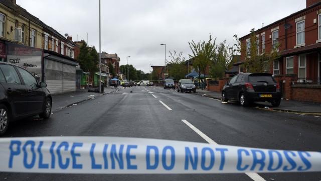 Garis polisi di lokasi penembakan di Claremont Road di lingkungan Moss Side, Manchester, Minggu (12/8/2018). (Foto: AFP/OLI SCARFF)