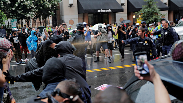 Petugas kepolisian menggunakan semprotan merica terhadap para demonstran saat peringatan satu tahun kekerasan rasial di Charlottesville, Virginia. (Foto: Reuters/Lucas Jackson)