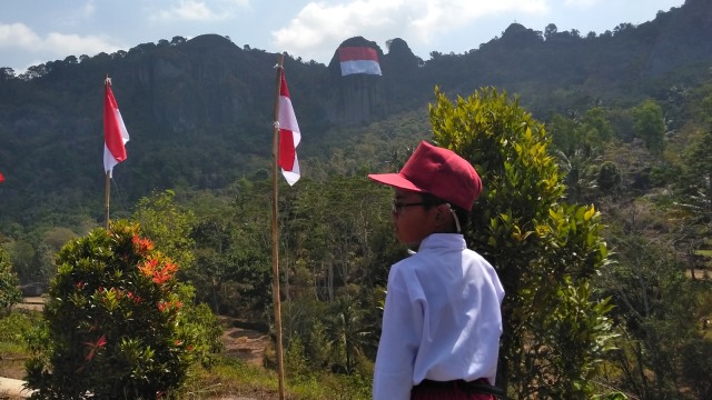 Pengibaran bendera merah putih berukuran besar di Gunung Api Purba Nglanggeran, Gunungkidul, Daerah Istimewa Yogyakarta, Senin (13/8/2018). (Foto: Arfiansyah Panji Purnandaru/kumparan)