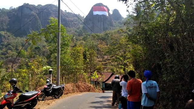Pengibaran bendera merah putih berukuran besar di Gunung Api Purba Nglanggeran, Gunungkidul, Daerah Istimewa Yogyakarta, Senin (13/8/2018). (Foto: Arfiansyah Panji Purnandaru/kumparan)