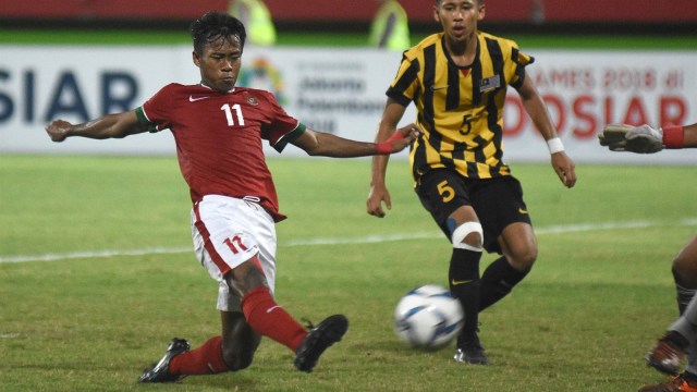 Pesepak bola Indonesia U-16 Muhammad Supriadi (kiri) berusaha melepaskan tendangan melewati adangan pesepak bola Malaysia U-16 Mohamad Ikhwan Mohd Hafizd (kanan) pada laga semifinal Piala AFF U-16 di Stadion Gelora Delta Sidoarjo, Jawa Timur, Kamis (9/8). Indonesia U-16 menang atas Malaysia U-16 dengan skor 1-0. (Foto: ANTARA FOTO/M Risyal Hidayat)