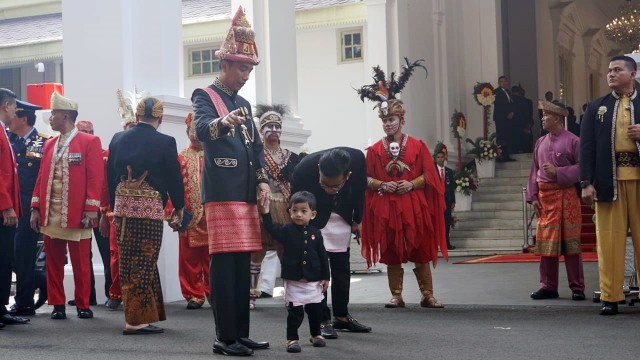 Presiden Jokowi (kiri) mengenakan baju adat Aceh bersama Gibran (kanan) dan Jan Ethes (tengah) di Istana Merdeka, Jakarta, Jumat (17/8/18). (Foto: Yudhistira Amran Saleh/kumparan)