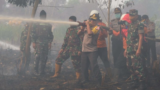 Petugas berjibaku padamkan kebakaran lahan gambut di Kalimantan Barat, Jumat (17/8/18). (Foto: dok Polda Kalbar)