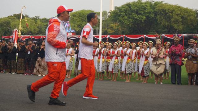 Presiden Jokowi bersiap membawa Obor Asian Games 2018 di Istana Merdeka, Jakarta, Jumat (17/8/18). (Foto: Yudhistira Amran Saleh/kumparan)