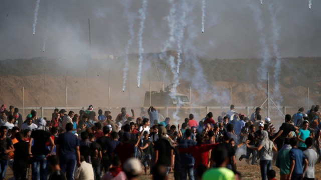 Gas air mata ditembakkan oleh pasukan Israel kepada demonstran Palestina selama protes menuntut hak untuk kembali ke tanah air mereka di perbatasan Israel-Gaza, Jumat (17/8/2018). (Foto: Reuters/Mohammed Salem)