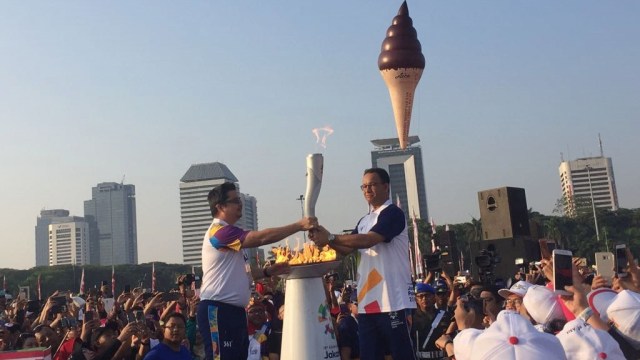 Gubernur Anies Baswedan membawa obor Asian Games 2018 di Monas, Sabtu (18/82018). (Foto: Moh Fajri/kumparan)