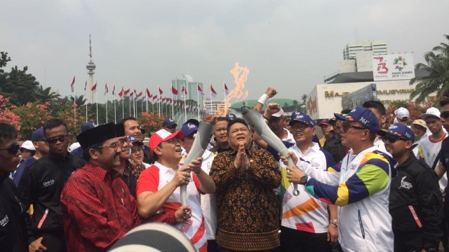 Wakil Ketua DPR Utut menyerahkan api Asian Games ke Bara Hasibuan, Sabtu (18/8/2018). (Foto: Moh Fajri/kumparan)