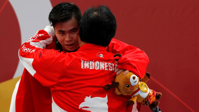 Edgar Marvelo dipeluk pelatihnya usai mendapat medali perak wushu. (Foto: Reuters/Beawiharta)