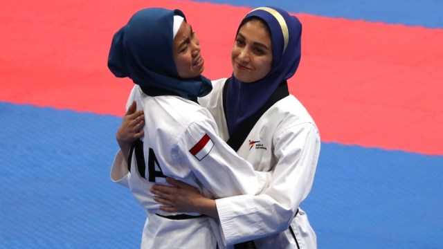 Taekwondoin Iran, Marjan Salahshouri, memberi selamat pada Defia Rosmaniar. (Foto: Reuters/Cathal Mcnaughton)