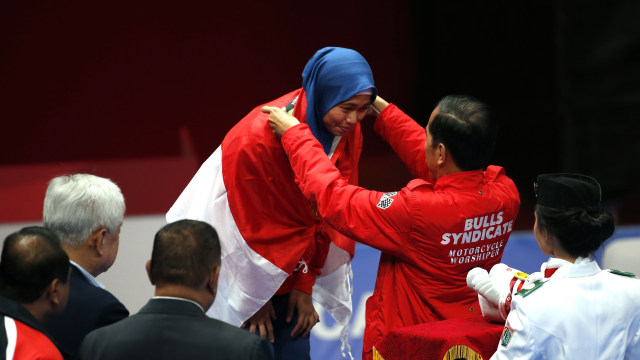 Presiden Joko Widodo mengalungkan medali emas untuk Defia Rosmaniar. (Foto: REUTERS/Willy Kurniawan)