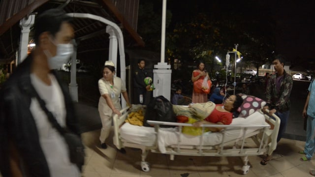 Petugas medis memindahkan pasien dari ruang perawatan ke luar ruangan usai terjadi gempa di RSUP Sanglah, Denpasar, Bali, Minggu (19/8). (Foto: Antara/Fikri Yusuf)