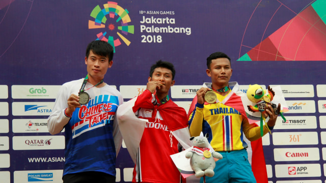 Atlet Sepeda Gunung Indonesia Khoiful Mukhib (tengah) mendapatkan medali emas, Chinese Taipei Sheng Shang Chiang (kiri) di posisi dua dan pebalap Thailand, Suebsakun Sukchanya (kanan) dengan perunggu, pada Asian Games ke-18 Tahun 2018. (Foto: ANTARA FOTO/INASGOC/Dwi Andri Purwanto/Spt/18.)