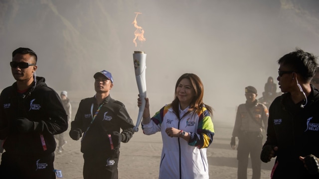 Susy Susanti membawa api Asian Games di Gunung Bromo. (Foto: AFP/Juni Kriswanto)