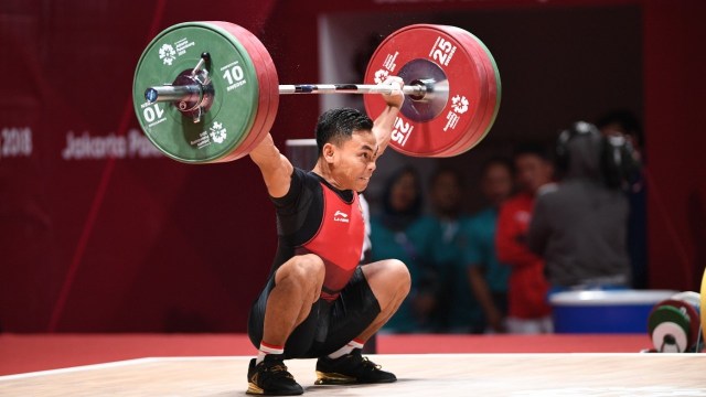 Lifter Indonesia Eko Yuli melakukan angkatan 'Snatch' angkat besi putra grup A nomor 62 kg Asian Games ke-18 di Jiexpo, Kemayoran, Jakarta, Selasa (21/8). (Foto: Helmi Afandi/kumparan)