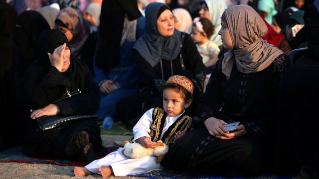 Warga Palestina sedang menunggu waktu solat Idul Adha di Kota Gaza, Palestina (21/8/2018). (Foto:  REUTERS/Ibraheem Abu Mustafa)