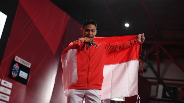 Lifter Indonesia Eko Yuli peraih emas saat berfoto bersama medalinya usai menjuarai angkat besi putra grup A nomor 62 kg Asian Games ke-18 di Jiexpo, Kemayoran, Jakarta, Selasa (21/8/2018). Foto: Helmi Afandi/kumparan