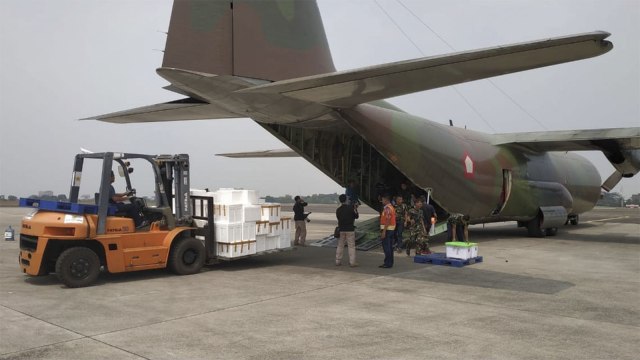 Anggota TNI Angkatan Udara mengangkut daging kurban ke pesawat hercules A-1320 untuk dibagikan kepada korban gempa di Lombok. (Foto: Dok. TNI)