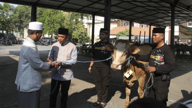 Kapolrestabes Surabaya Kombes Pol Rudi Setiawan menjadi penyembelih sapi kurban di Mapolrestabes Surabaya usai salat Idul Adha, Rabu (22/8/2018). (Foto: Phaksy Sukowati/kumparan)