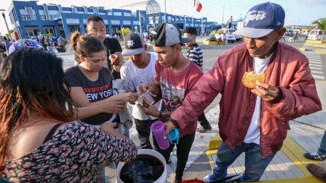 Warga Venezuela menerima makanan dari volunter. (Foto: CRIS BOURONCLE / AFP)