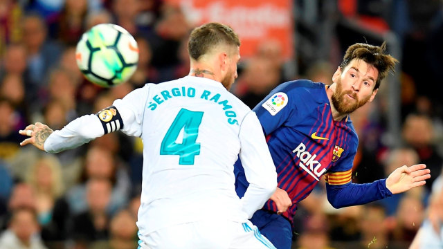 Sergio Ramos berupaya menghalangi Lionel Messi. Foto: AFP/Lluis Gene