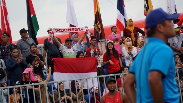 Penonton memberikan dukungan kepada tim voli pantai putra Indonesia di Jakabaring Sport City, Palembang, Selasa (28/8). Foto: Fanny Kusumawardhani/kumparan