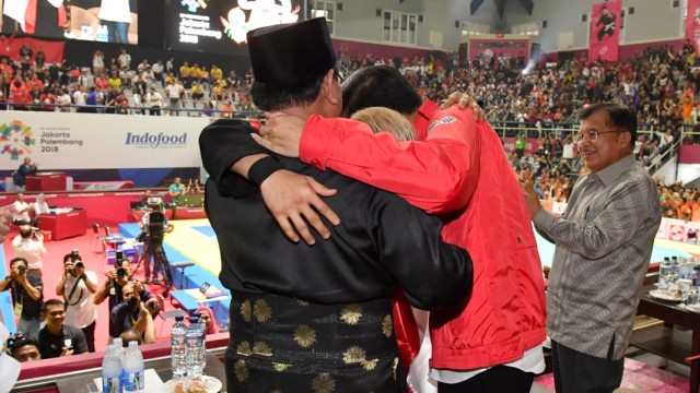 Prabowo dan Jokowi berpelukan bersama dengan peraih emas laga final pencak silat Asian Games 2018, Rabu (29/8/18). (Foto: Biro Pers Setpres)