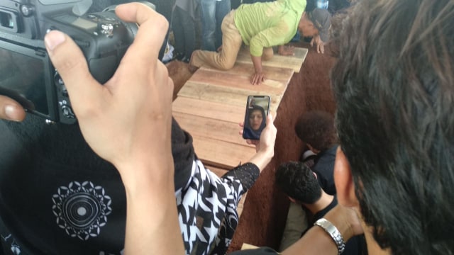 Ibunda Faldy Albar menyaksikan penguburan putranya melalui video call, Kamis (30/8/18). (Foto: Alexander Vito/kumparan)