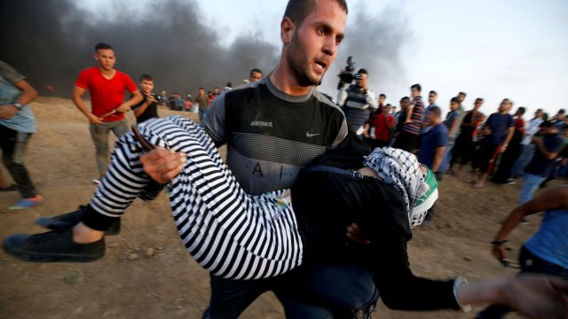 Bentrokan warga Palestina dan tentara Israel di pagar perbatasan antara Israel dan Gaza. (Foto: Reuters/Mohammed Salem)